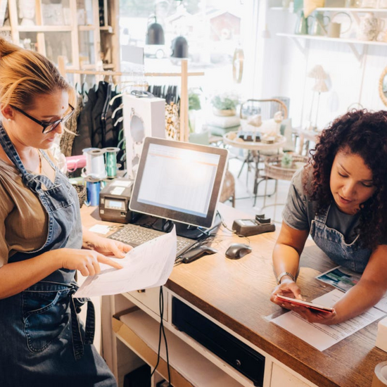 Two women discuss bookkeeping in Retail Shop